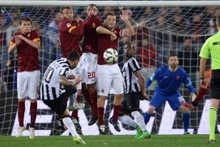 Penyerang Juventus, Carlos Tevez, mencetak gol melalui tendangan bebas saat melawan AS Roma, pada pertandingan lanjutan Serie-A, Senin (2/3/2015). 