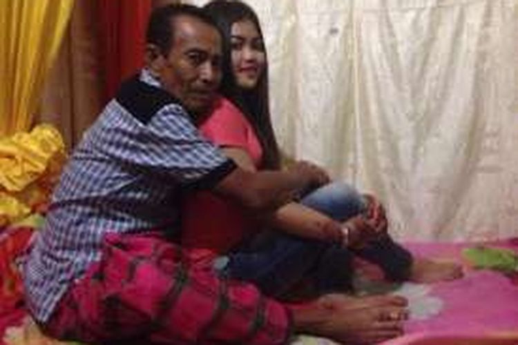 Nasir (63) tengah berfoto mesra bersama isterinya, Mila (18) saat menikmati bulan madunya pasca pernikahannya dua hari yang lalu di Kabupaten Bone, Sulawesi Selatan. Rabu, (13/07/2016).