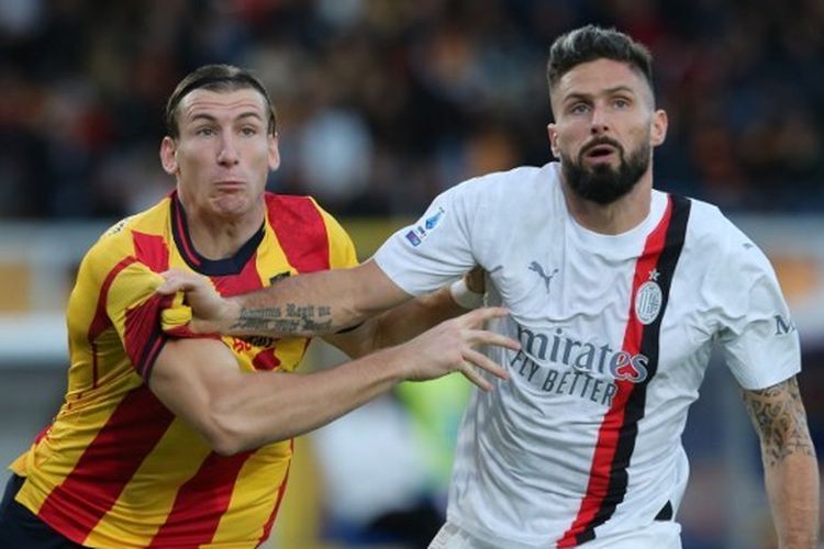 Penyerang AC Milan, Olivier Giroud (kanan), berebut bola dengan bek Lecce, Federico Baschirotto. Laga Lecce vs Milan tersebut digelar di Stadion Via del Mare pada Sabtu (11/11/2023) malam WIB.