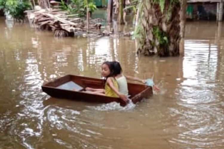 Dua bocah perempuan, Nesya dan Azua, bermain di tengah banjir yang melanda sejumlah desa dan kelurahan di Kotawaringin Barat, Kalimantan Tengah, Minggu (5/7/2020). 