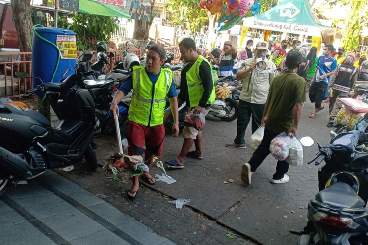 Para pelanggar yang ketahuan tidak memakai masker di luar rumah di Kabupaten Gresik, saat menjalani hukuman kerja sosial membersihkan fasilitas umum yang telah disepakati.