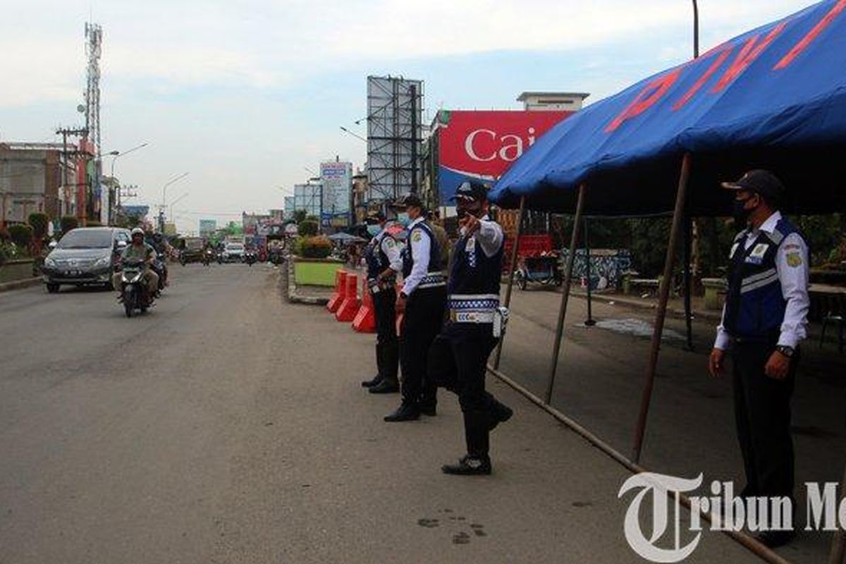 Petugas Dinas Perhubungan (Dishub) Kota Medan terlihat mengatur arus lalu lintas di posko penyekatan perbatasan Medan-Deliserdang, di Kampung Lalang, Medan, Sabtu (10/7/2021). Mulai hari Ini, 12 Juli 2021 sudah berlaku PPKM Darurat.
