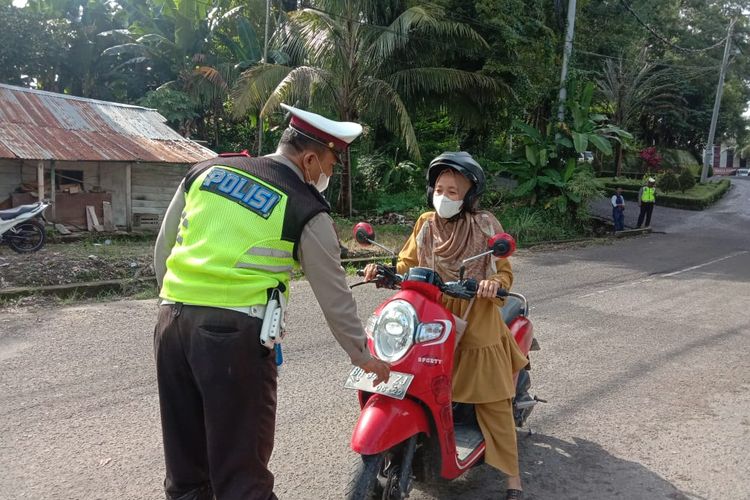 Petugas kepolisian saat memeriksa plat nomor warga saat pemberlakukan ganjil genap di tempat wisata Danau Sipin, Kota Jambi