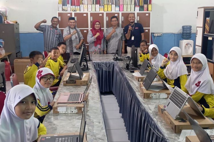 Kepala sekolah dan siswa SDN Pinang Ranti 02 saat menerima bantuan laptop dalam program Lenovo Computer Lab for Education.