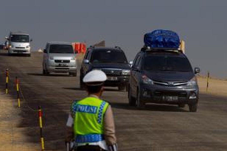 Polisi mengatur lalu lintas di ruas Tol Pejagan-Brebes, Jawa Tengah, saat arus mudik H-6 menjelang Lebaran, Sabtu (11/7/2015). Tol Pejagan-Brebes dioperasikan untuk mengurangi kemacetan arus mudik Lebaran Idul Fitri 1436 H meski kondisi fisik jalan masih kurang baik.