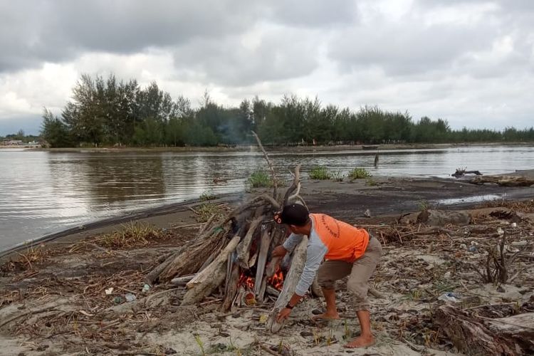 Tim BPBD Aceh Singkil membakar bangkai babi yang diangkut di Pulau Sarok, Aceh Singkil, Jumat (22/11/2019)