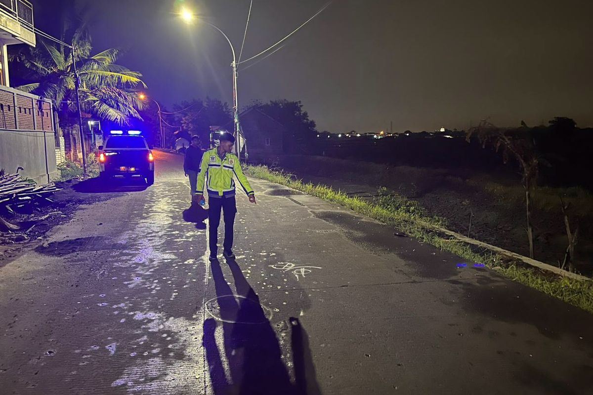 Polisi menunjukkan lokasi kecelakaan lalu lintas di jalan umum Desa Kedanyang, Kecamatan Kebomas, Gresik, Jawa Timur, Kamis (16/11/2023).