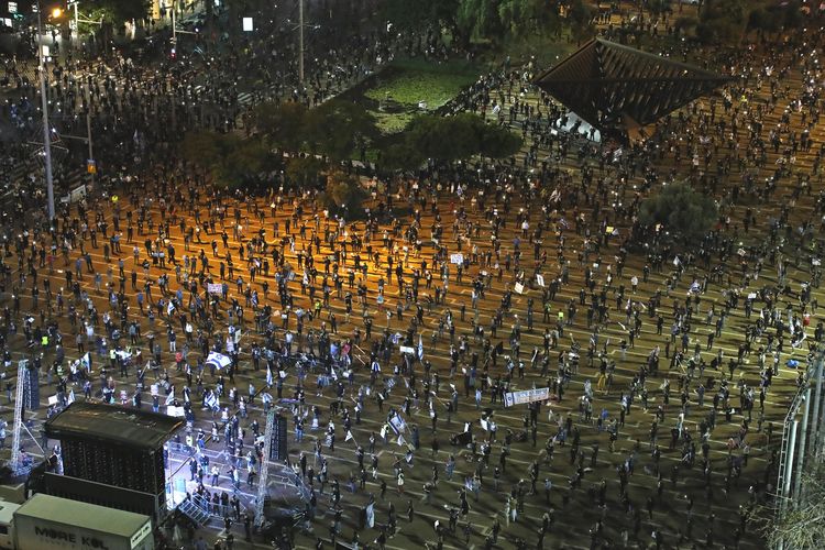 Demonstran Israel tetap menjaga jarak aman di social distancing dan memakai masker, saat unjuk rasa menuntut Perdana Menteri Benjamin Netanyahu lengser dari jabatannya. Aksi unjuk rasa dilakukan di Rabin Square pada Minggu (19/4/2020).