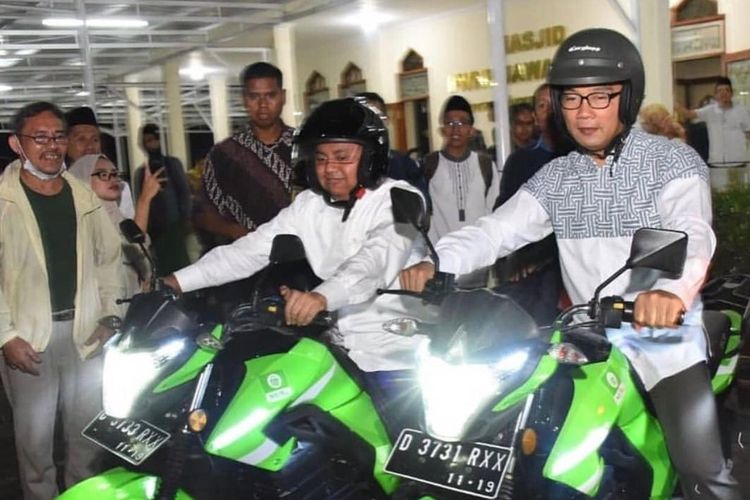 Gubenur Jawa Barat Ridwan Kamil dan Wakil Gubernur Jabar Uu Ruzhanul Ulum mencoba motor listrik. Motor listrik ini digunakan untuk pengembangan ojek online berbasis motor listrik untuk pesantren dan masjid di Jabar. 