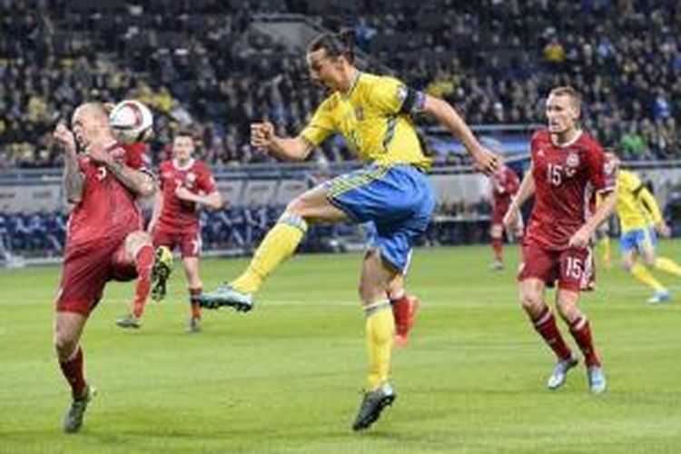 Penyerang Swedia Zlatan Ibrahimovic (tengah) dibayang-bayangi oleh bek Denmark Simon Kjaer (kiri) pada laga play-off Piala Eropa 2016 di Stadion Friends Arena, Solna, Sabtu (14/11/2015).