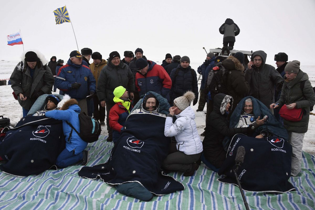 Tiga astronot pulang kampung. (Ki-ka) Joe Acaba, Alexander Misurkin, dan Mark Vande Hei dibungkus selimut setelah keluar dari pesawat ruang angkasa Soyuz MS-06 yang mendarat di Kazakhstan. 