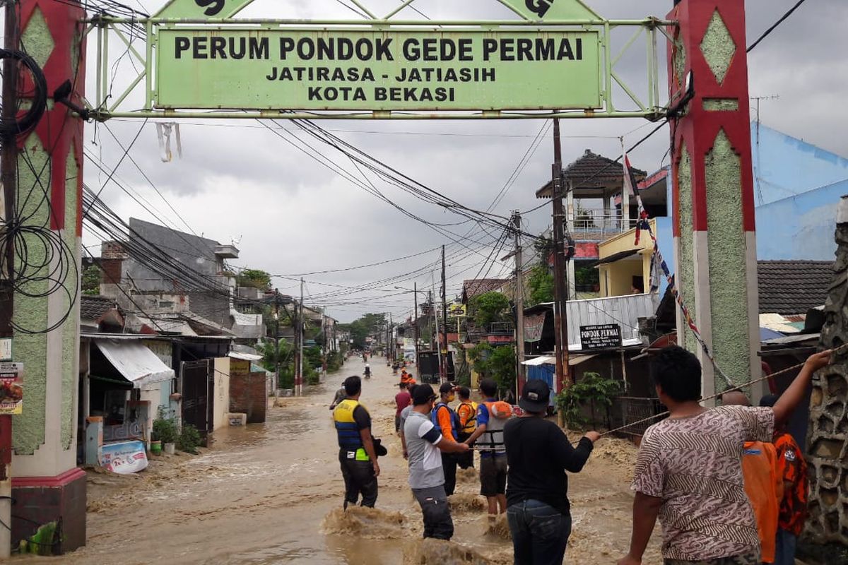 Tali tambang dibentangkan untuk mengevakuasi warga Pondok Gede Permai di tengah derasnya arus banjir pada Jumat (19/2/2021).