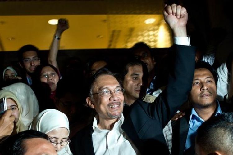 Tokoh oposisi Malaysia, Anwar Ibrahim, disambut para pendukungnya saat meninggalkan gedung Pengadilan Tinggi Malaysia di Putrajaya, Jumat (7/3/2014), usai mendengarkan putusan pengadilan yang mengabulkan banding pemerintah. 