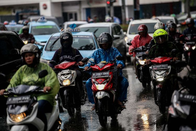Pengguna kendaraan bermotor menembus hujan di Jalan Menteng Raya, Jakarta, Jumat (22/2/2019). Badan Meteorologi, Klimatologi, dan Geofisika ( BMKG) memprediksi hujan akan mengguyur wilayah Jabodetabek pada Jumat (22/2/2019) siang.