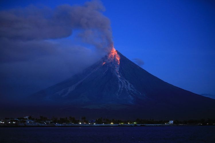 Lahar keluar dari gunung berapi Mayon. Pemandangan ini terlihat dari kota Legazpi, provinsi Albay, Filipina, pada Selasa (23/1/2018) pagi. (AFP/Charism Sayat)