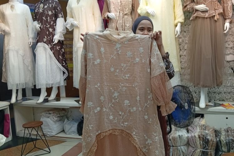 Pramuniaga menunjukkan model baju gamis 'bini orang' yang saat ini sedang naik daun di Pasar Tanah Abang, Jumat (13/2/2026).
