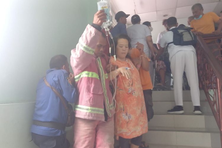 Foto: Petugas Damkar Pematang Siantar membantu mengevakuasi pasien keluar ruang rawat inap saat peristiwa kebakaran salah satu gudang di Lantai V RS Vita Insani Pematang Siantar, Senin 3 Juli 2023.
