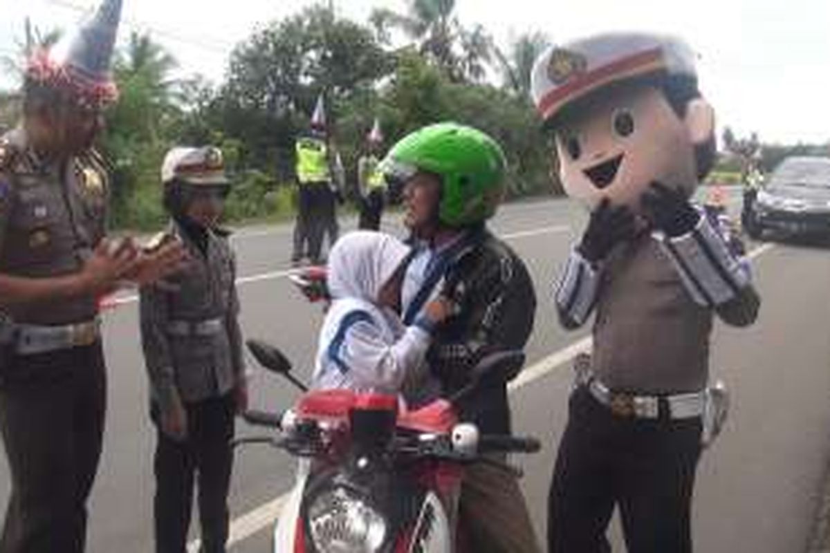 Polisi Lalu Lintas Aceh Besar bersama polisi cilik dan badu polis member pemahaman kepada pengguna jalan untuk melengkapi sayarat berkendaraan seperti enggunakan helm bagi penumpang yang dibonceg termasuk anak-anak, dalam rangka peringatan HUT Lalulintas ke61 di jajaran Polres Aceh Besar, Rabu (21//2016)
