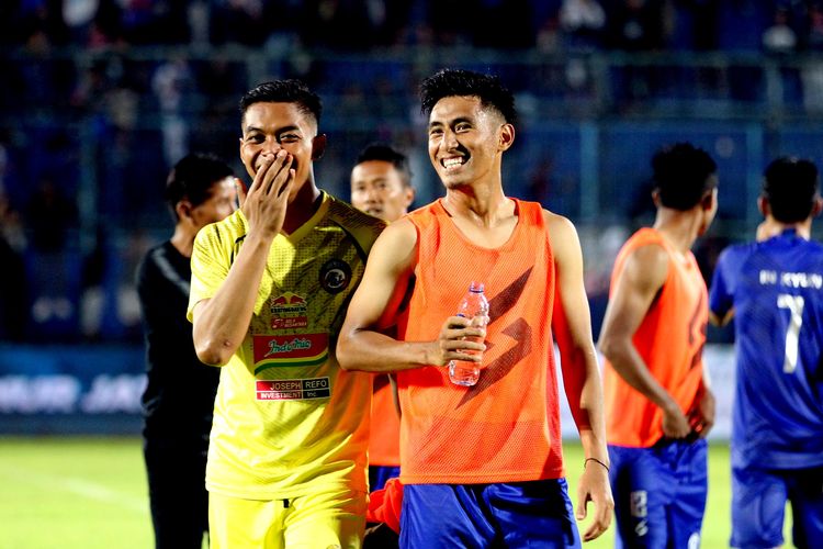 Hanif Sjahbandi bergurau seusai pertandingan bersama penjaga gawang Arema FC Teguh Ammiruddin (kanan).