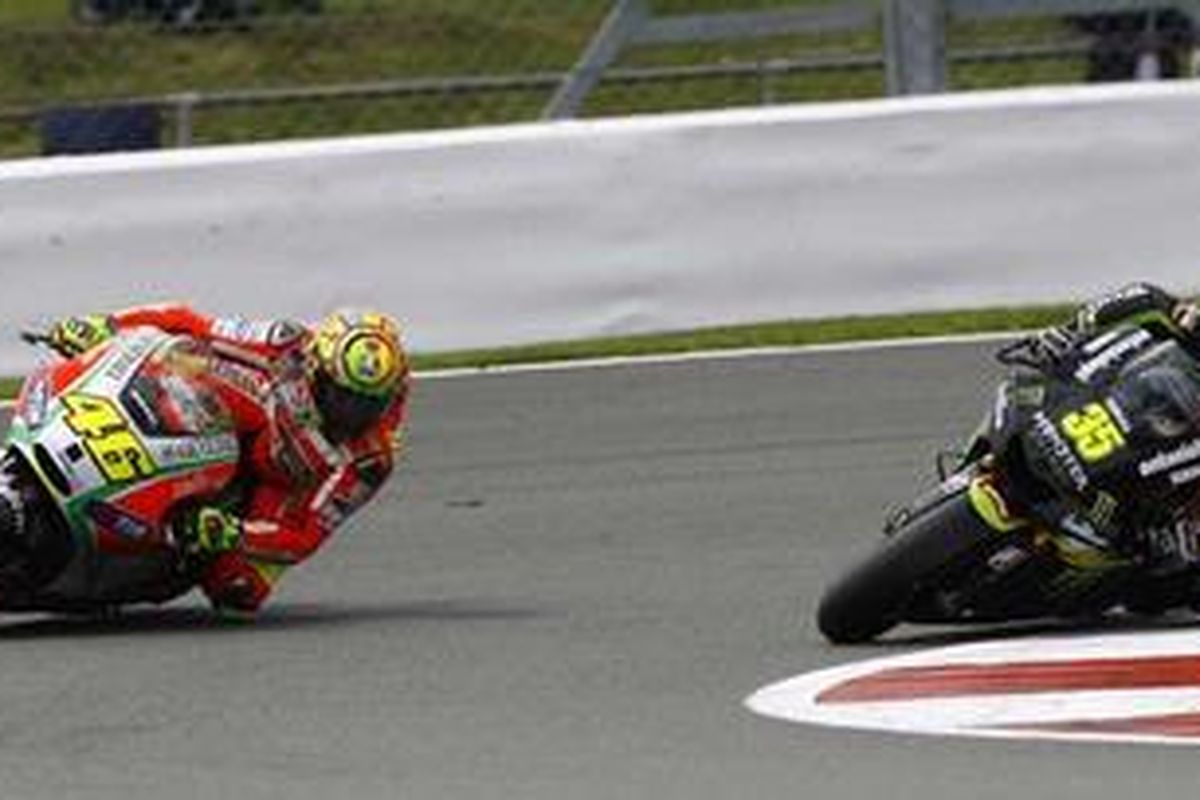 Pebalap Ducati, Valentino Rossi (kiri), bersaing dengan pebalap Yamaha Tech 3, Cal Crutchlow.