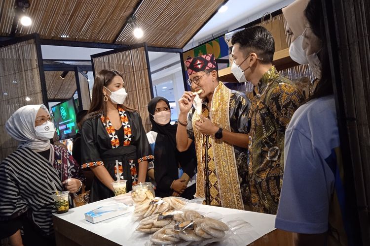Menteri Pariwisata dan Ekonomi Kreatif, Sandiaga Uno saat mencicipi kerupuk kemplang di gelaran Apresiasi Kreasi Indonesia 2021, Sabtu (23/10/2021).