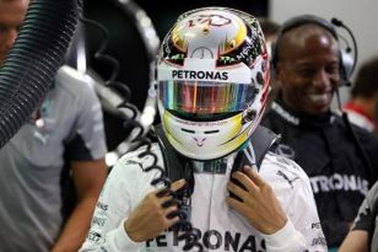 Pebalap Mercedes asal Inggris, Lewis Hamilton, bersiap di paddock Sirkuit Internasional Bahrain pada sesi latihan kedua GP Bahrain, Jumat (4/4/2014).