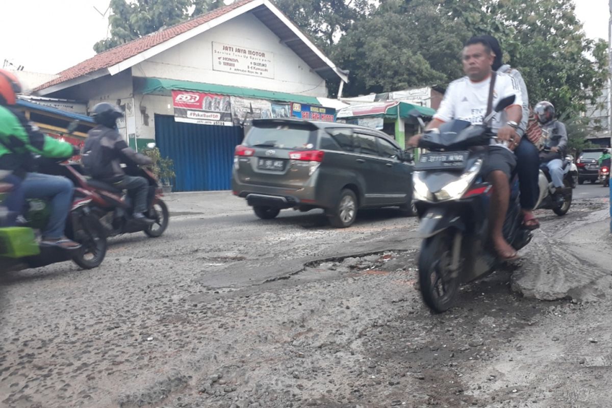 Tampak Jalan Raya Jatimulya, Pengasinan, Kecamatan Bekasi Timur, Kota Bekasi rusak dan berlubang menimbulkan kemacetan, Jumat (7/12/2018).