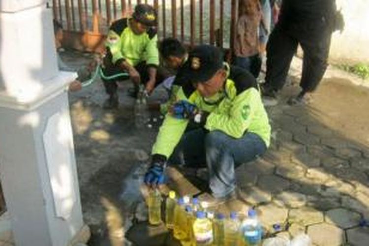 Sejumlah anggota Pareanom sedang memasukkan bensin ke botol bekas air mineral sebelum melakukan 