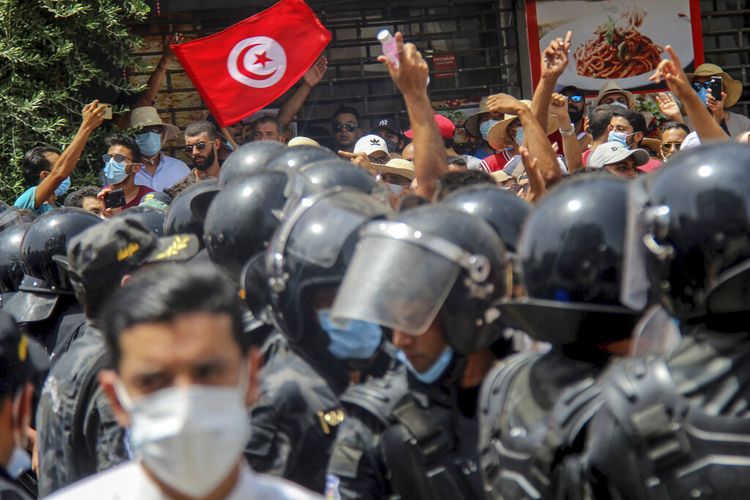 Para pengunjuk rasa menghadapi petugas polisi Tunisia selama demonstrasi di Tunis, Tunisia, Minggu (25/7/2021). Demonstrasi dengan kekerasan pecah pada Minggu di beberapa kota Tunisia ketika pengunjuk rasa menyatakan kemarahan atas memburuknya situasi kesehatan, ekonomi, dan sosial negara itu.