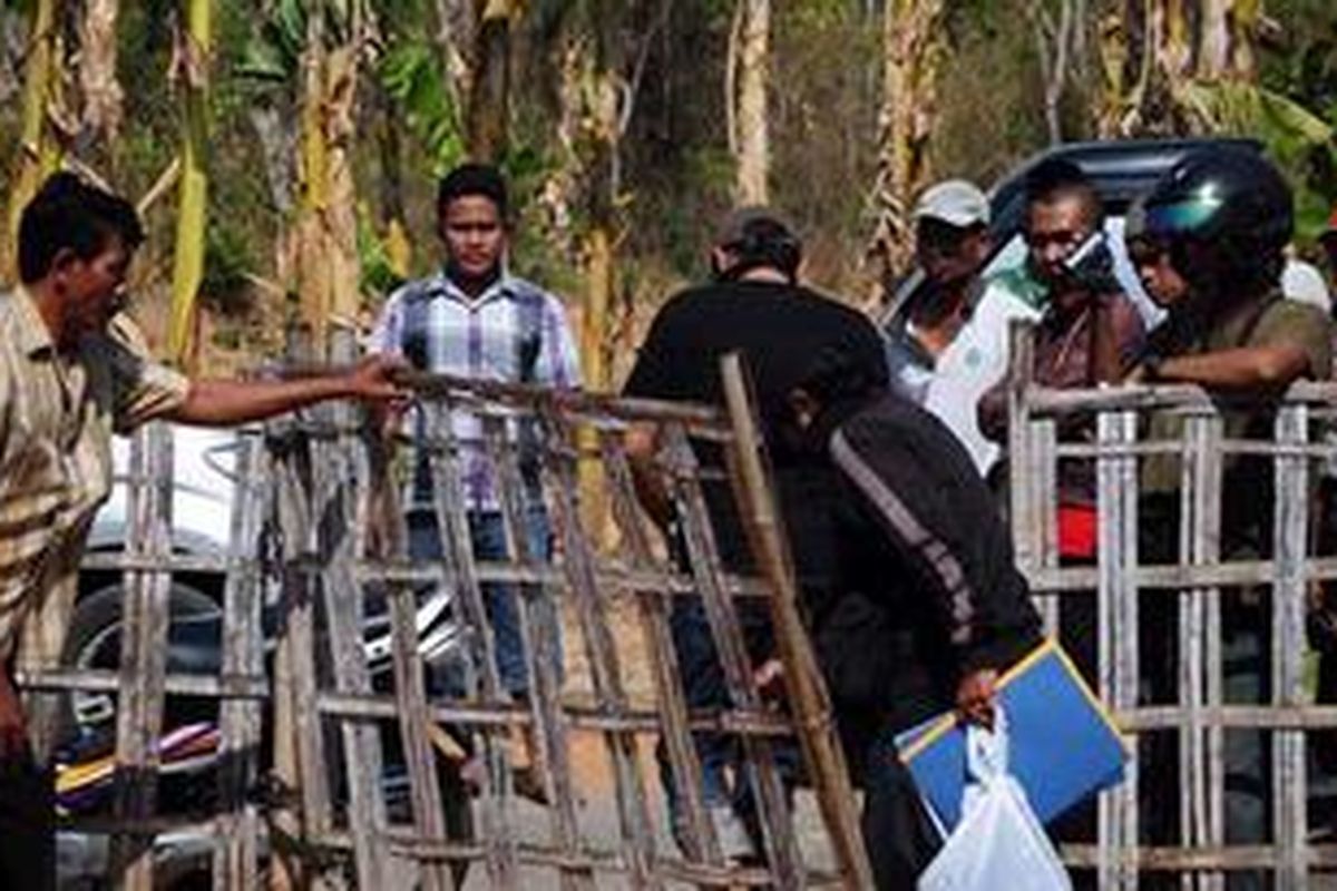 Dua anggota identifikasi Polda Jawa Timur, membawa berkas gasil penggeledahan di rumah yang diduga menjadi tempat pelarian teroris.