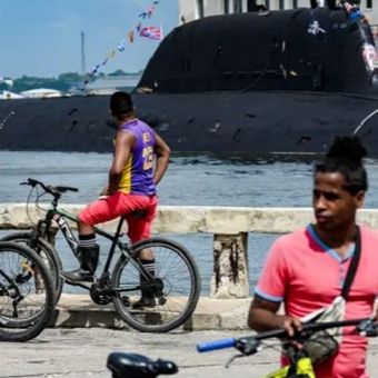 Warga Havana, Kuba, menonton kapal selam bertenaga nuklir Rusia, Kazan, yang merupakan bagian dari konvoi angkatan laut Rusia yang mengunjungi Kuba, setelah tiba di pelabuhan Havana tanggal 12 Juni 2024.