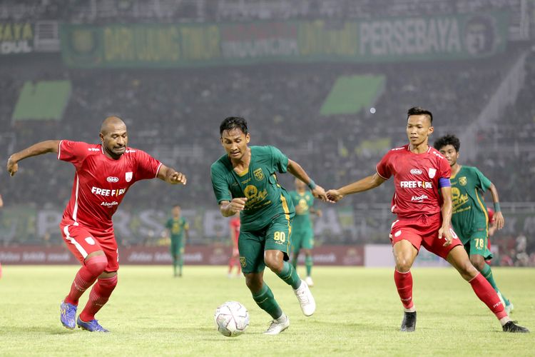 Pemain Persebaya Surabaya Januar Eka dijaga ketat pemain Persis Solo Andri Ibo saat uji coba dalam rangka ulang tahun Kota Surabaya yang ke 729 yang berakhir dengan skor 1-2 di Stadion Gelora Bung Tomo Surabaya, Minggu (22/5/2022) sore.