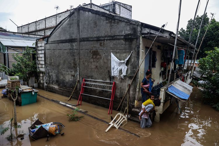 Warga saat meninggalkan rumahnya akibat banjir di Pejaten Timur, Pasar Minggu, Jakarta Selatan, Senin (8/2/2021). Banjir setinggi 30-150 cm yang melanda tiga RW di Pejaten Timur itu disebabkan oleh luapan air Sungai Ciliwung.