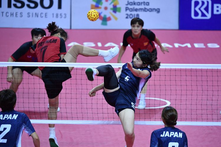 Pemain sepak takraw asal Jepang Yuumi Kawamata (# 5) Duong Thi Xuyen (# 7) mencoba memblok serangan lawan di babak penyisihan kuadran putri grup B Asian Games 2018 di Palembang pada 30 Agustus 2018. (Photo by ADEK BERRY / AFP)