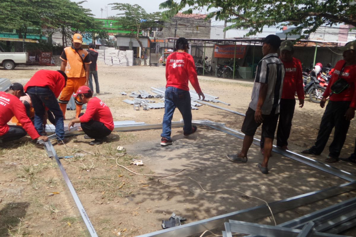 Petugas PPSU dan Pasukan Merah sedang mengerjakan rangka bangunan rumah dari baja ringan. Pasukan merah merupakan petugas yang didatangkan oleh PT Tatalogam selaku pemberi CSR pembangunan bedah rumah yang dicanangkan Pemprov DKI di Cilincing, Jakarta Utara, Jumat (28/4/2017)