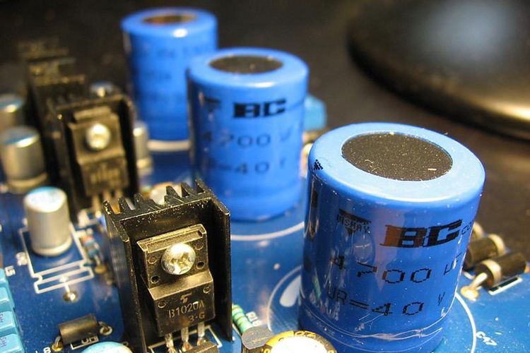 Tiga buah tabung biru pada rangkaian elektronik merupakan susunan kapasitor yang disusun seri.