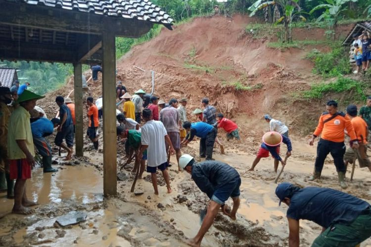 Warga dan relawan membersihkan material longsor yang menerjang rumah warga di Kabupaten Banjarnegara, Jawa Tengah, Selasa (15/3/2022).