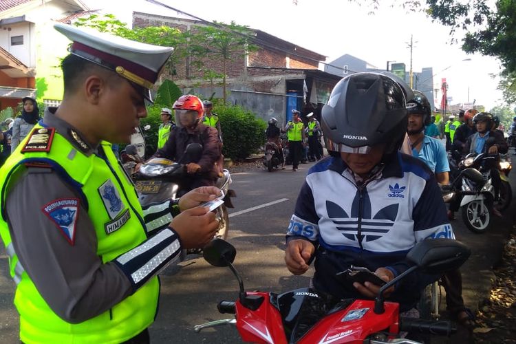 Kasat Lantas Banyumas AKP Himawan Aji Angga memeriksa kelengkapan surat-surat kendaraan bermotor di Purwokerto, Senin (29/4/2019)
