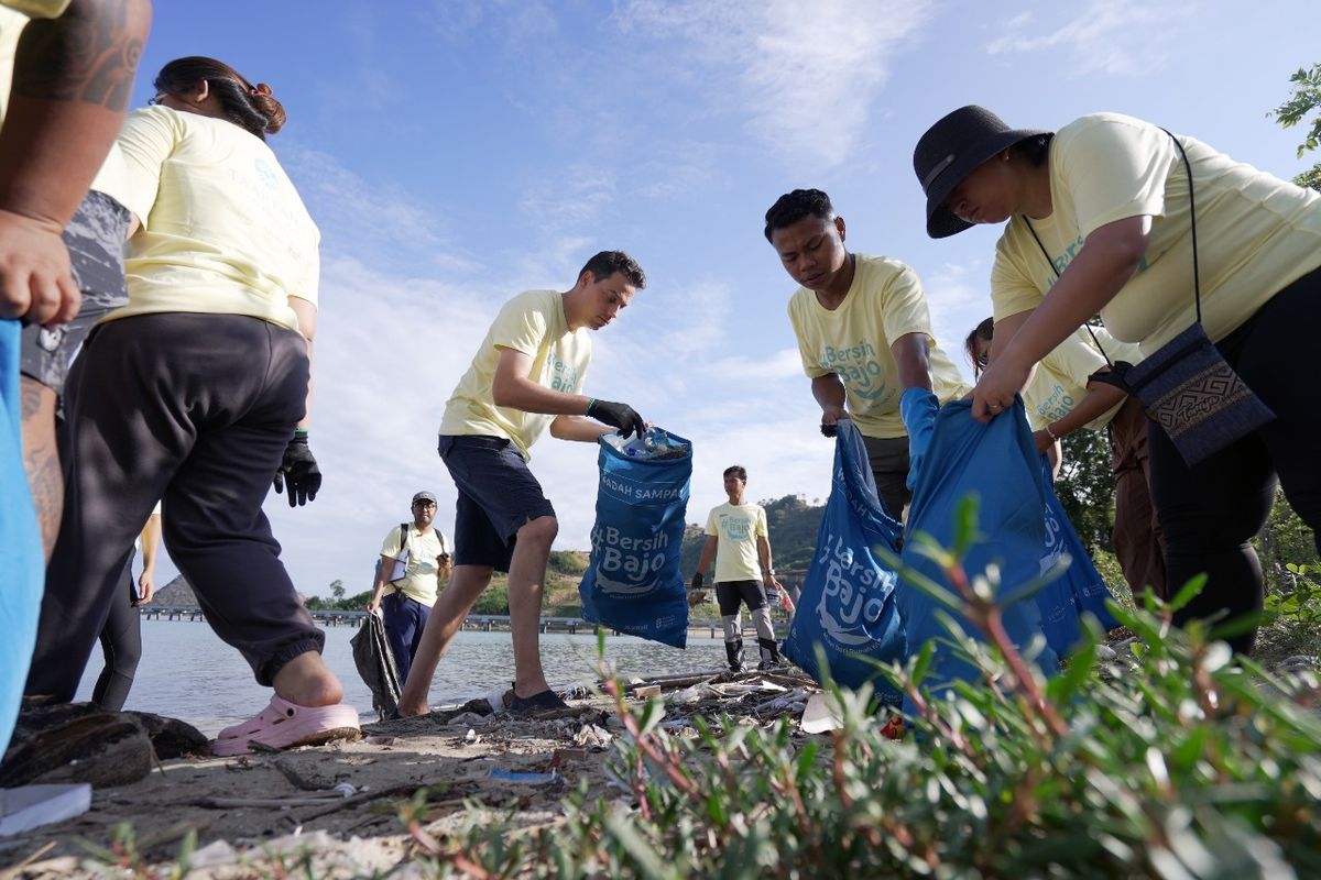 Para peserta Bersih Bajo Chapter 4 memungut sampah di pesisir Pantai Wae Rana.