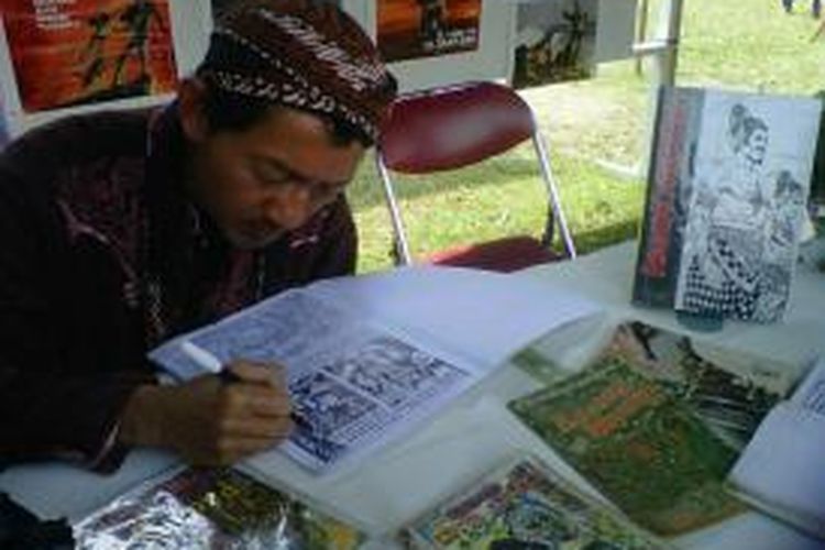 Supardi terlihat tekun mengerjakan salah satu komik karyanya di sebuah pameran di Alun-alun Kota Magelang belum lama ini.