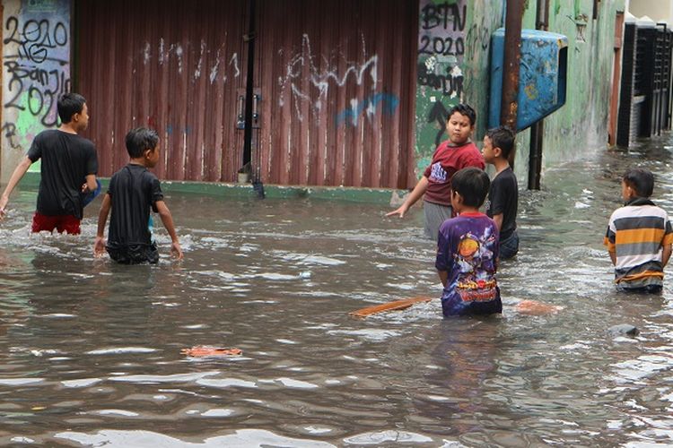 Sejumlah anak-anak bermain di tengah genangan banjir di Komplek BTN, Kelurahan Sukabumi Selatan, Kebon Jeruk, Jakarta Barat, Rabu (1/1/2020) siang.