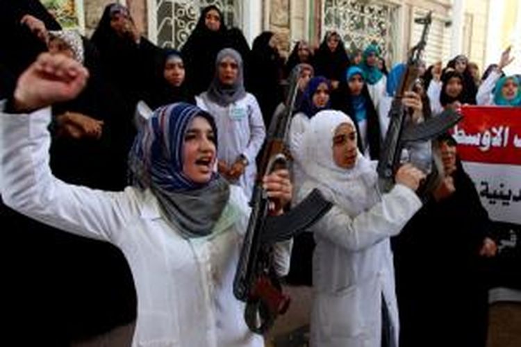 Para perempuan Syiah Irak sambil menenteng senapan serbu AK-47 sebagai perlambang tekad mereka melawan gerak maju militan ISIS.