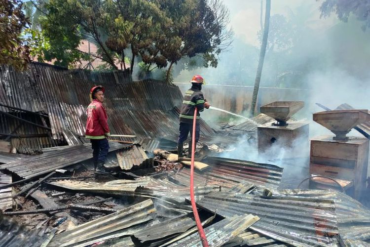 Petugas Damkar Kota Padang tengah memadamkan api yang membakar gudang milik Bulog pada Jumat (12/8/2022) siang. 