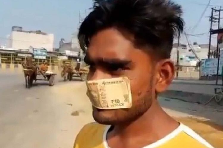 Inilah momen ketika Ahmad, seorang pekerja di Meerut, India, terpaksa mengenakan uang pecahan 10 rupee sebagai masker karena tak punya cukup uang untuk membelinya.