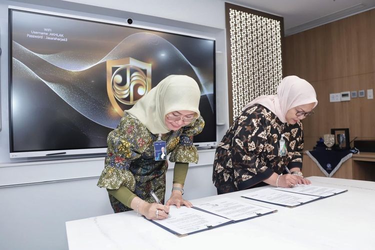 Direktur Operasional Jasa Raharja Dewi Aryani Suzana dan Direktur Pelayanan BPJS Ketenagakerjaan Roswita Nilakurnia terlihat menandatangani Perjanjian Kerja Sama terkait program jaminan kecelakaan kerja dan lalu lintas di Jakarta, Selasa (15/10/2024). 