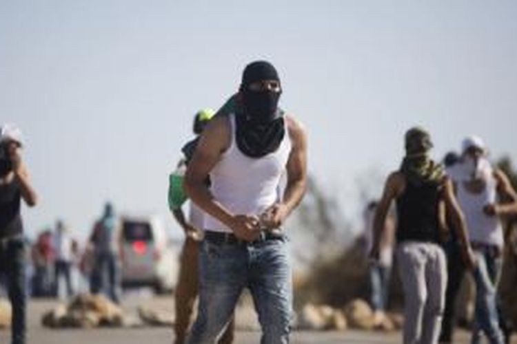 Demonstran Palestina melemparkan batu ke arah pasukan keamanan Israel dalam aksi protes atas tewasnya seorang warga Palestina di Duma dekat Nablus, Tepi Barat (8/8).