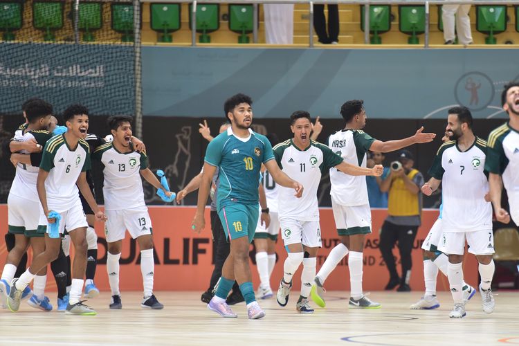 Pemain timnas futsal Indonesia, Evan Soumilena (hijau), tertunduk di tengah para pemain Arab Saudi yang melakukan selebrasi. Indonesia gagal lolos ke putaran final Piala Asia Futsal 2024 usai kalah 2-3 dari Arab Saudi pada laga terakhir kualifikasi di Green Hall, Dammam, pada Rabu (11/10/2023) malam waktu setempat.