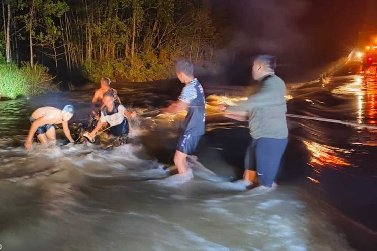 Anggota Satgas Yonif 111/KB lakukan proses penyelamatan 2 warga yang terseret arus banjir di jalan Trans Papua, Minggu (30/06/2024).