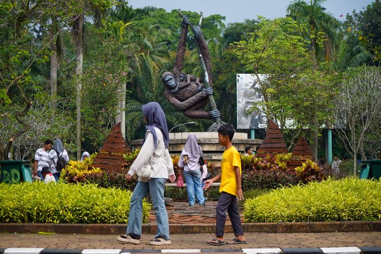 Pengunjung berfoto di Taman Margasatwa Ragunan, Jakarta, Sabtu (28/6/2025). Libur panjang akhir pekan dimanfaatkan warga Jakarta dan sekitarnya untuk berlibur bersama keluarga. Untuk masuk Taman Margasatwa Ragunan, pengunjung membayar tiket sebesar Rp 3.000 untuk anak-anak dan Rp 4.000 untuk dewasa.