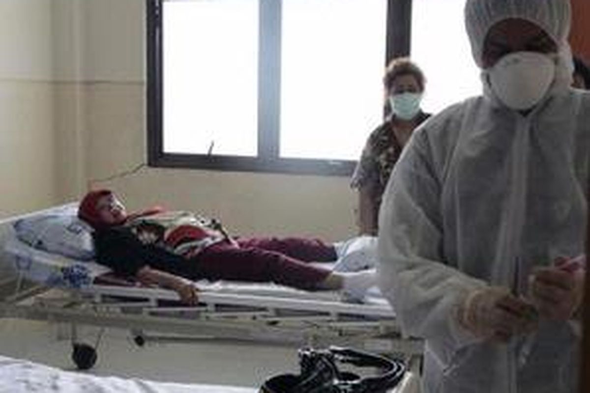 Petugas medis berpakaian lengkap mengambil sampel swap nasofis (sampel lendir) terhadap pasien berinisial SM (56) yang diduga terjangkit virus H1N1 penyebab flu babi di RSUD Arifin Achmad Pekanbaru, Senin (8/6)